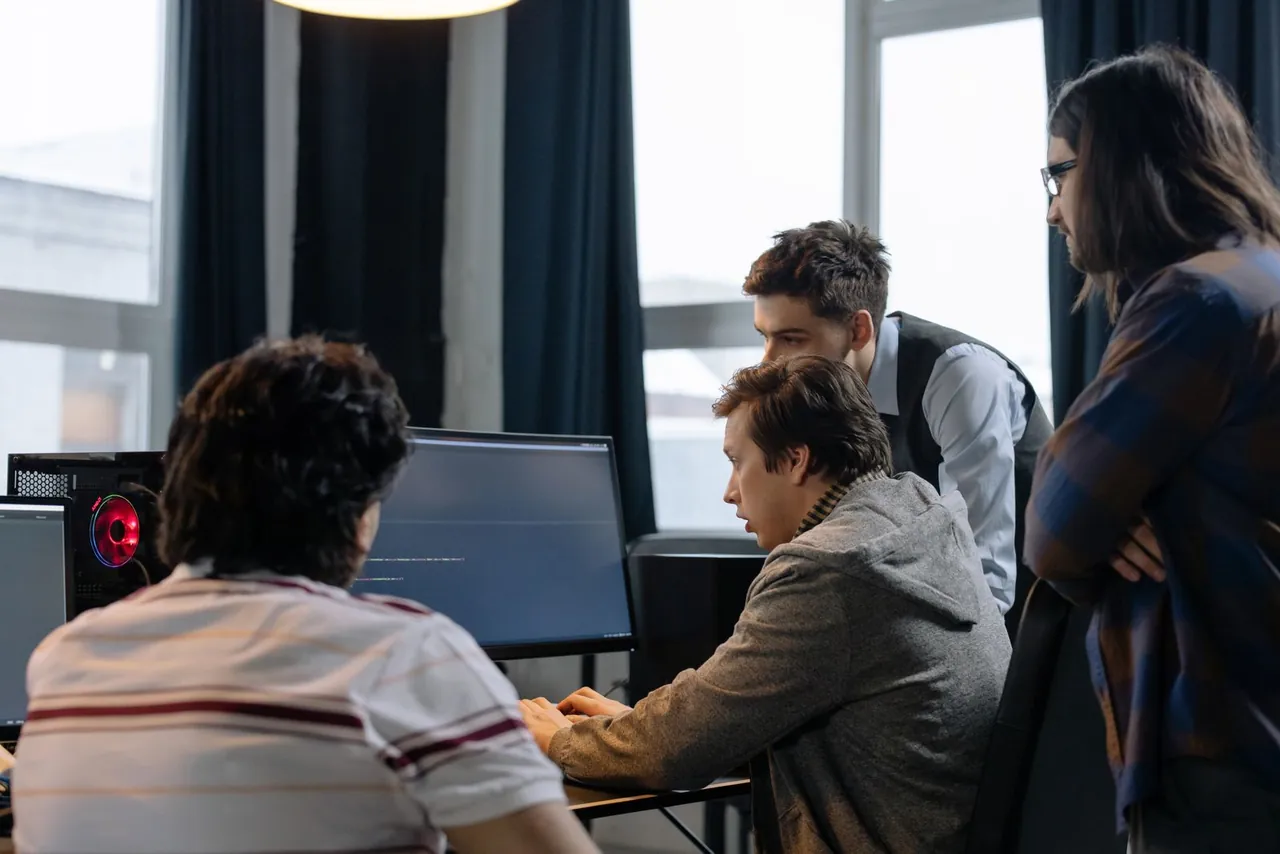 Vier Personen besprechen gemeinsam die Arbeit am Computer.