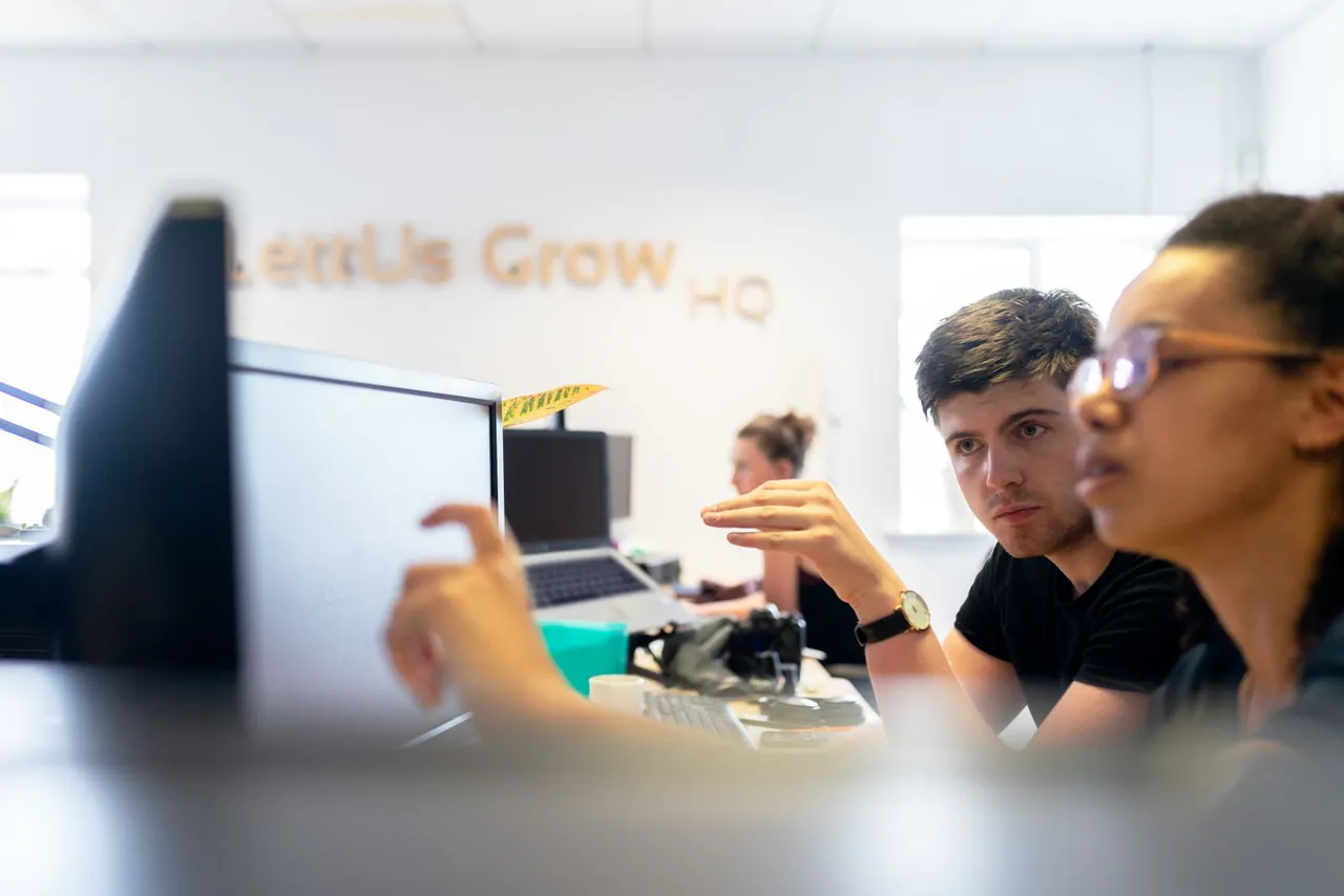 Zwei Personen besprechen Inhalte auf einem Bildschirm im Büro.